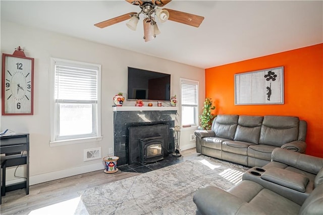 living room with a ceiling fan, wood finished floors, visible vents, and baseboards