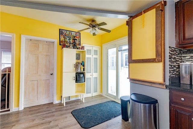 doorway to outside featuring baseboards, ceiling fan, and light wood finished floors