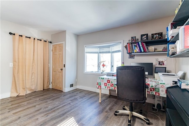 home office featuring wood finished floors, visible vents, and baseboards