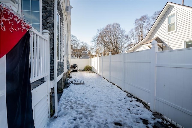 yard layered in snow featuring a fenced backyard