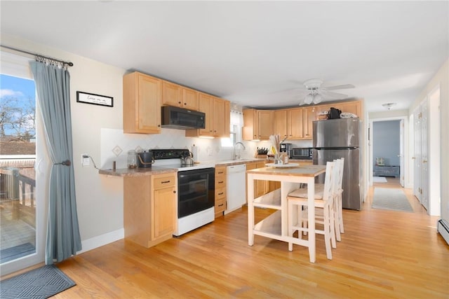 kitchen featuring light brown cabinets, electric stove, a sink, freestanding refrigerator, and black microwave