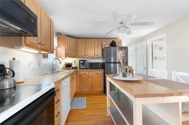 kitchen with white dishwasher, freestanding refrigerator, range with electric cooktop, black microwave, and wood counters