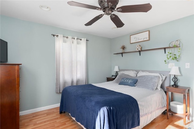 bedroom with wood finished floors, baseboards, and ceiling fan