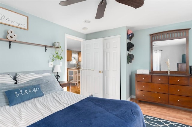 bedroom with light wood-style flooring, baseboards, a closet, and ceiling fan