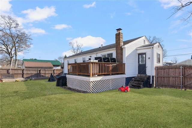 back of house featuring a yard, a fenced backyard, a chimney, entry steps, and a deck