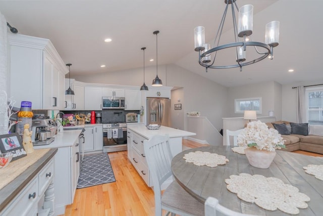 kitchen featuring an inviting chandelier, light countertops, appliances with stainless steel finishes, white cabinetry, and light wood-type flooring