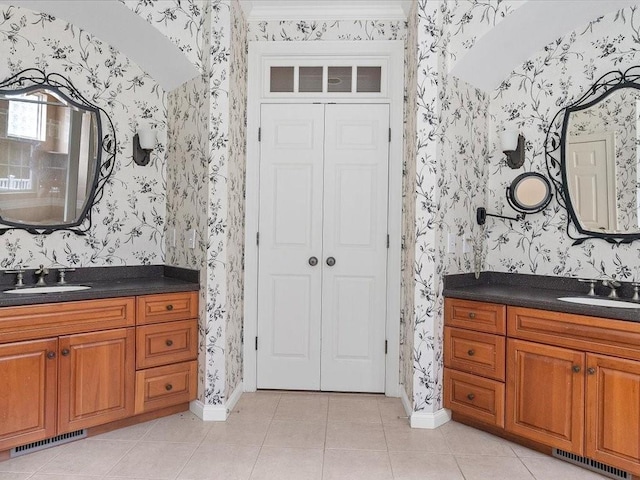 bathroom with visible vents, wallpapered walls, and a sink