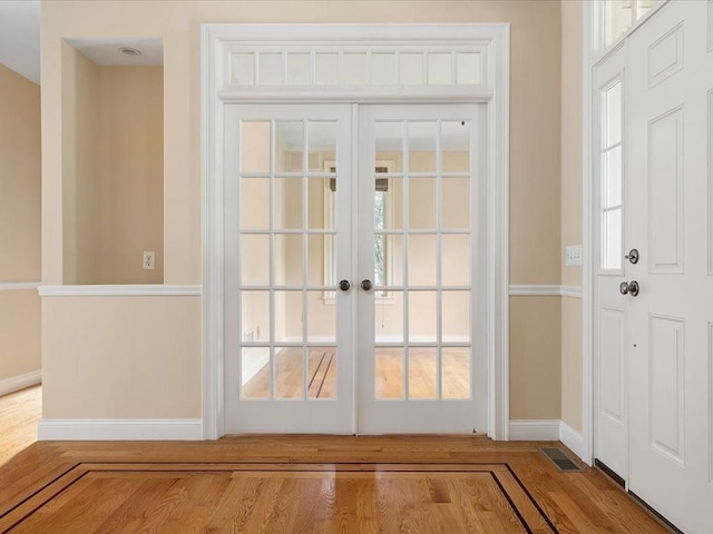 doorway to outside with visible vents, french doors, baseboards, and wood finished floors