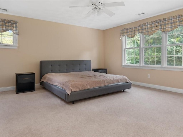 carpeted bedroom with visible vents, baseboards, and a ceiling fan