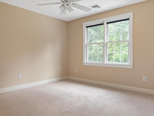 unfurnished room featuring visible vents, light carpet, baseboards, and ceiling fan