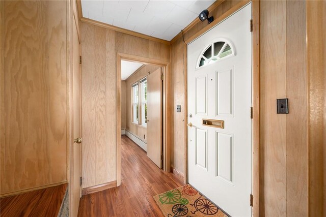 277 Waterman St, Providence, RI 02906 - foyer with wood walls, wood finished floors, a baseboard heating unit, and ornamental molding