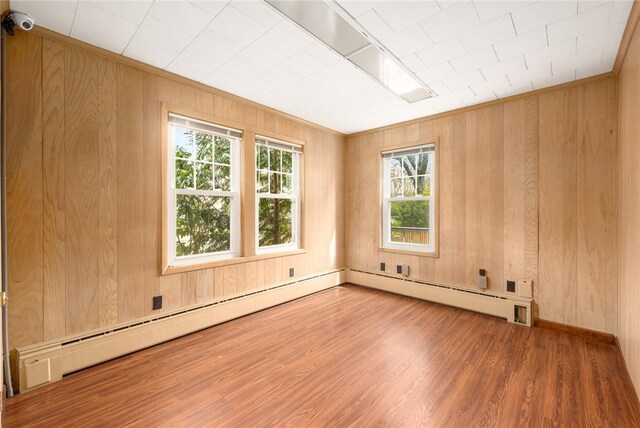 277 Waterman St, Providence, RI 02906 - empty room featuring wood walls, a baseboard radiator, and wood finished floors