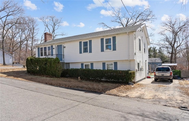 view of front of home featuring driveway and a chimney