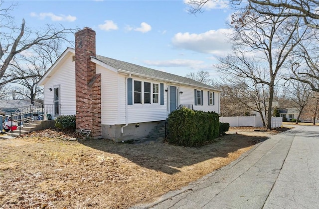 view of front of house featuring a chimney and fence