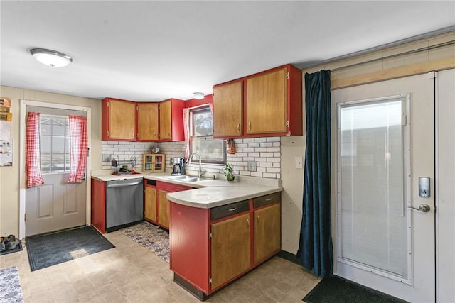 kitchen with dishwasher, a peninsula, light floors, and light countertops