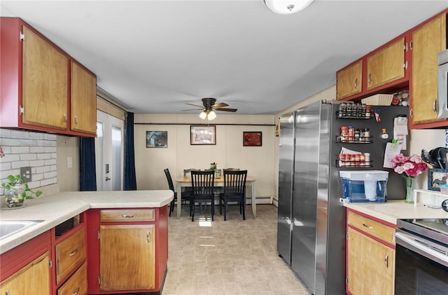 kitchen with backsplash, appliances with stainless steel finishes, light countertops, and a peninsula