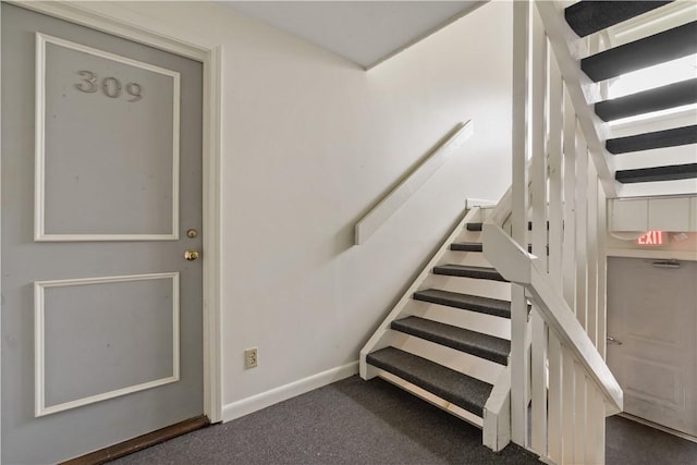 staircase featuring baseboards and carpet flooring