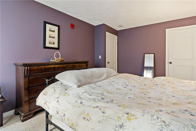 bedroom with baseboards and light carpet