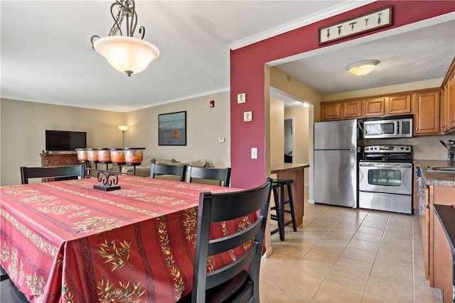 dining area with light tile patterned floors and ornamental molding