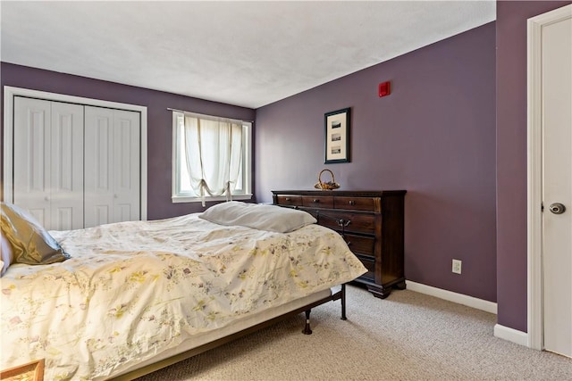 bedroom with light carpet, a closet, and baseboards