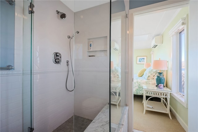 ensuite bathroom featuring connected bathroom, tiled shower, and a wall mounted AC