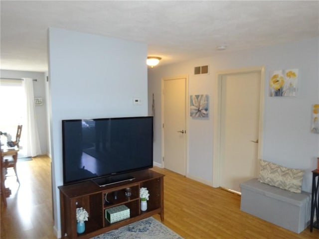 living room featuring visible vents and wood finished floors