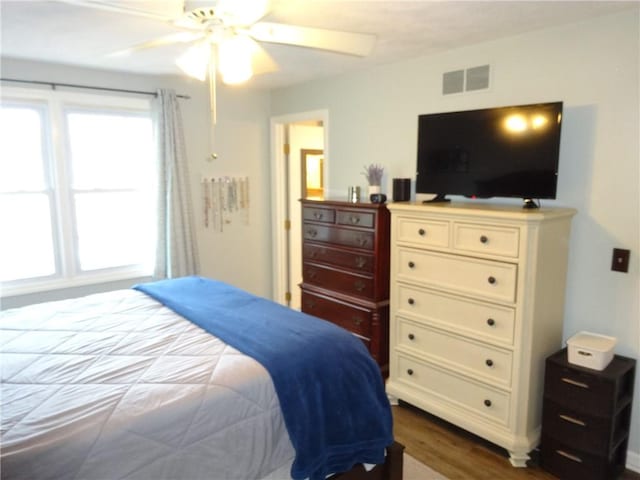 bedroom featuring visible vents, a ceiling fan, and dark wood-style flooring