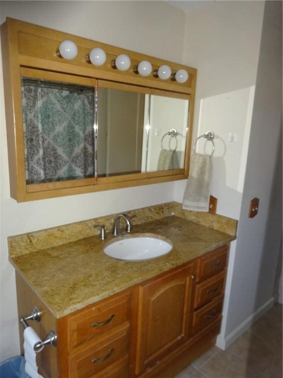 full bathroom featuring tile patterned flooring, vanity, and baseboards