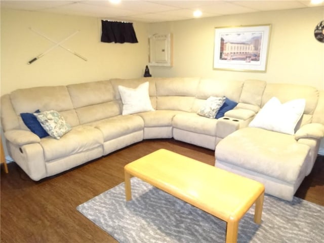 living area featuring electric panel, wood finished floors, and a drop ceiling