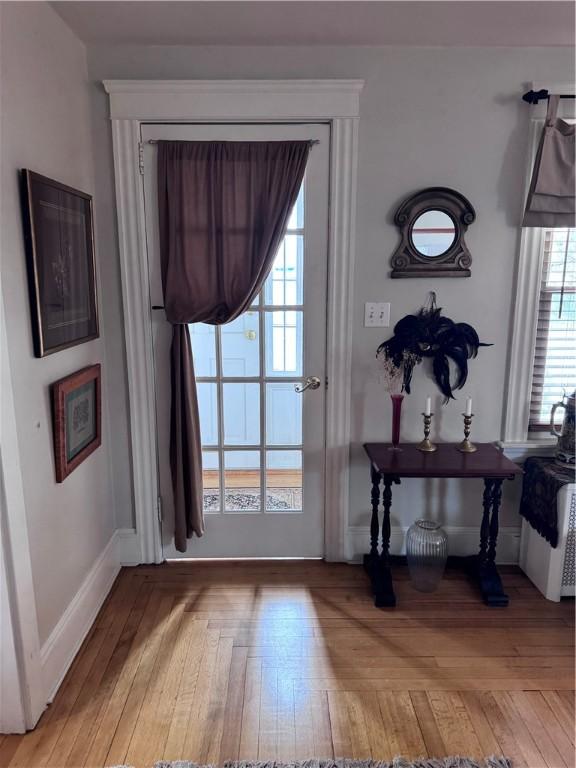 doorway to outside with baseboards and light wood-type flooring