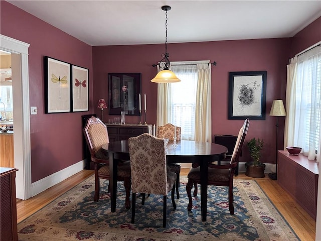 dining space with baseboards and wood finished floors