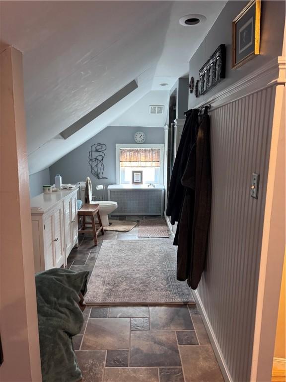 mudroom featuring visible vents, lofted ceiling, and stone tile flooring