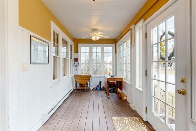 sunroom with ceiling fan and a baseboard radiator