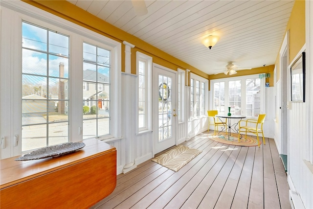 unfurnished sunroom featuring a ceiling fan