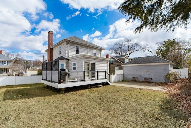 rear view of house with a deck, fence, a lawn, and a chimney