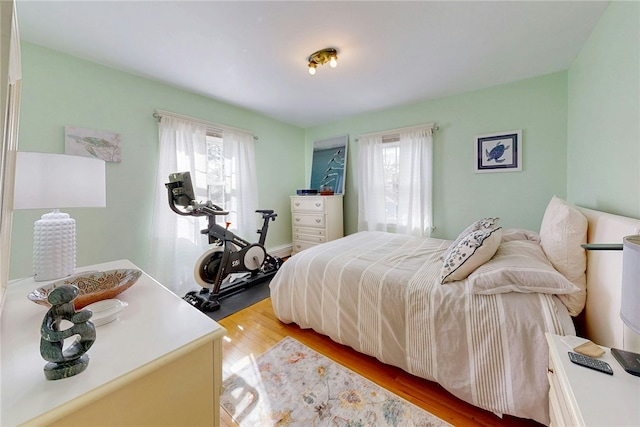 bedroom featuring multiple windows and light wood finished floors