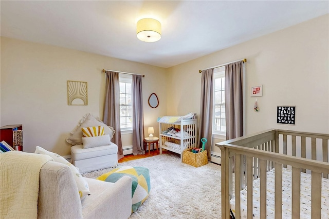 bedroom with a crib and a baseboard radiator