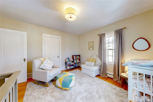 living area featuring light wood finished floors and baseboard heating