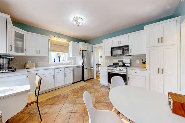 kitchen featuring white cabinetry, appliances with stainless steel finishes, and a sink