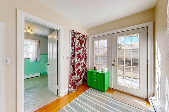 doorway with a baseboard heating unit, tile walls, a wainscoted wall, and french doors