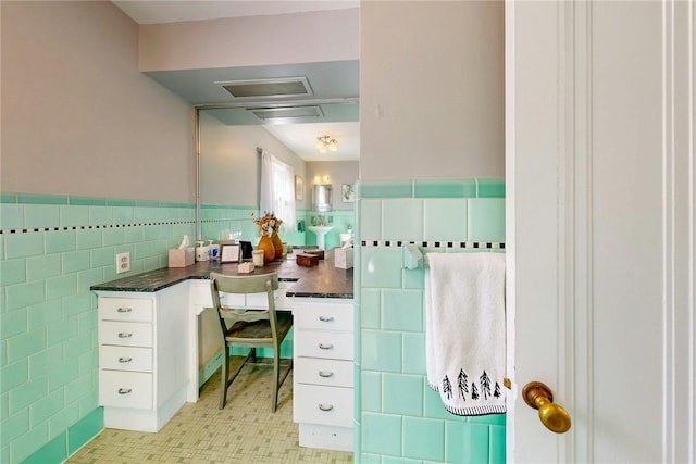 bathroom featuring a wainscoted wall and tile walls