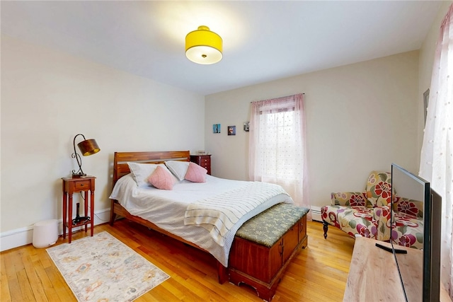 bedroom with baseboard heating and light wood-type flooring