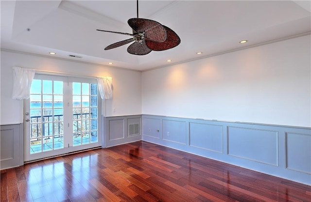 unfurnished room with a decorative wall, recessed lighting, wood finished floors, and visible vents