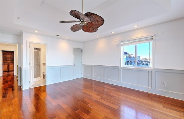 spare room with visible vents, wainscoting, recessed lighting, wood finished floors, and a ceiling fan