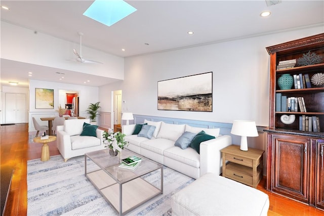 living area with recessed lighting, a skylight, and light wood-type flooring