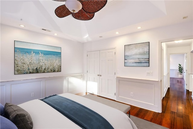 bedroom featuring visible vents, a wainscoted wall, recessed lighting, a decorative wall, and dark wood-style flooring