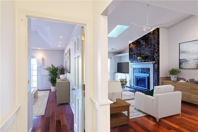 living area featuring a wainscoted wall, wood finished floors, recessed lighting, a fireplace, and a decorative wall