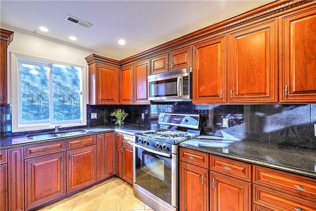 kitchen featuring visible vents, a sink, tasteful backsplash, appliances with stainless steel finishes, and light tile patterned floors