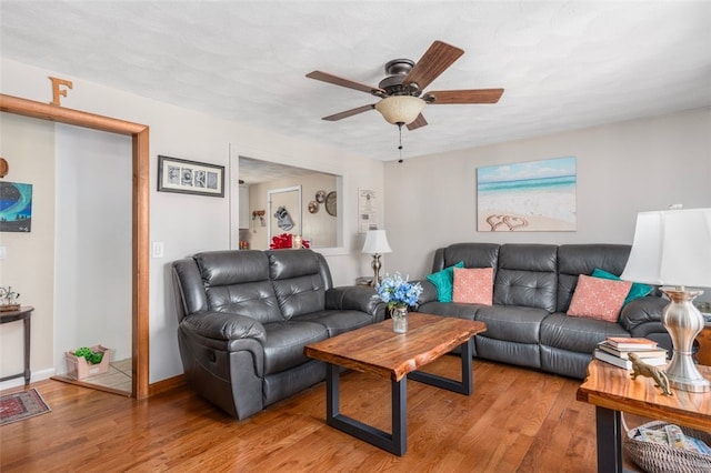 living area with ceiling fan, baseboards, and wood finished floors