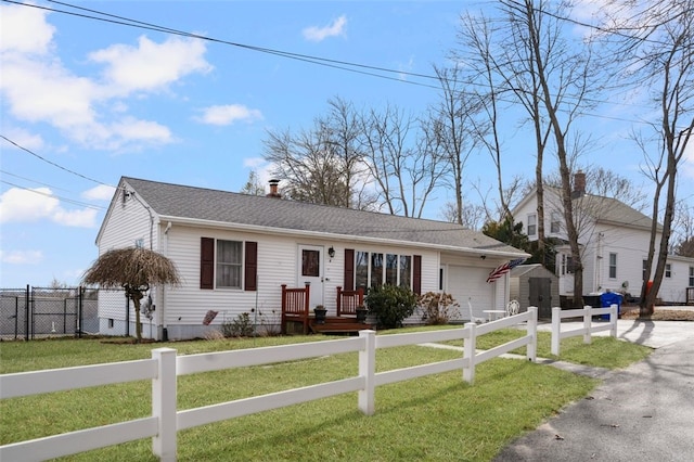 view of front of property featuring a front yard, roof with shingles, a garage, a fenced front yard, and aphalt driveway